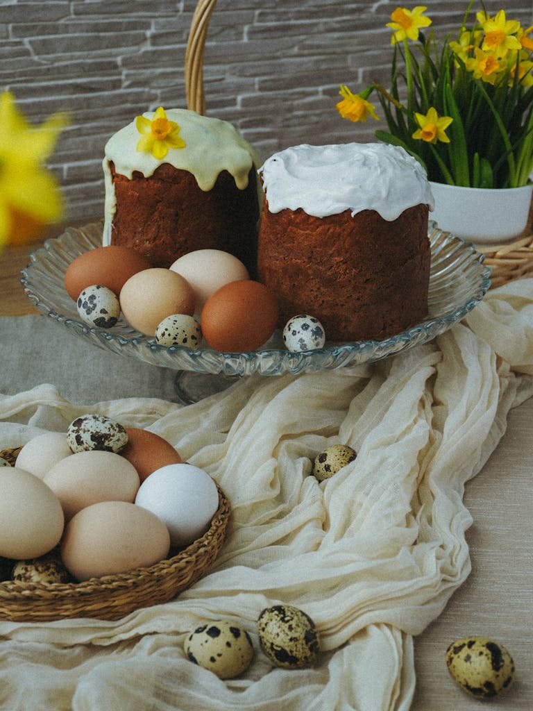 Festive setup of Easter cakes and various eggs surrounded by vibrant daffodils.